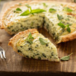 Spinach and herb Florentine quiche on a cutting board for breakfast