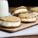 A thin, crispy gluten free chocolate chip cookie with vanilla ice cream sandwiched between.