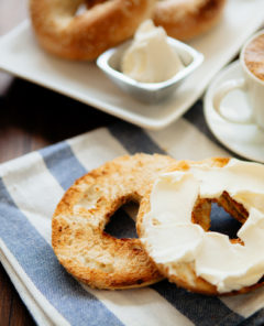 Montreal style bagels on a plate with cream cheese and coffee