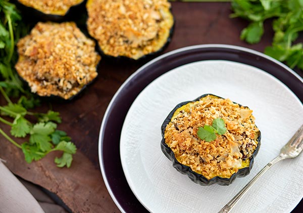 Quinoa Stuffed Baked Acorn Squash on a plate with more squash halves in the background