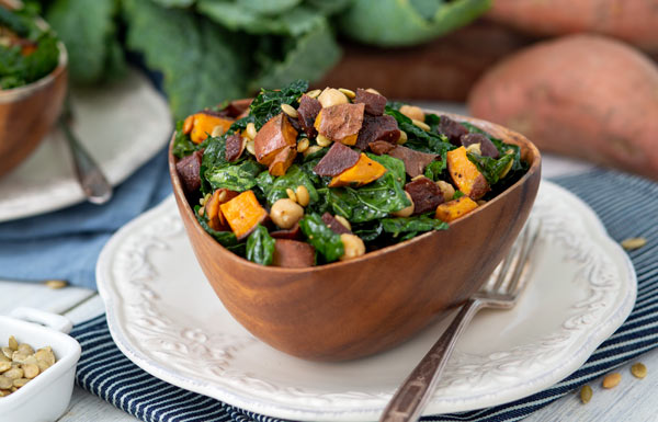 A bowl of Kale Superfood Salad with sweet potatoes.