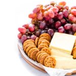 Gluten Free Seasoned Crackers on a platter with cheese and grapes