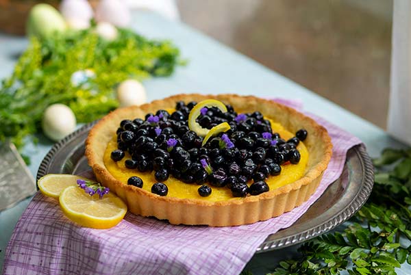 Lemon Blueberry Pie on a plate with fresh blueberries.