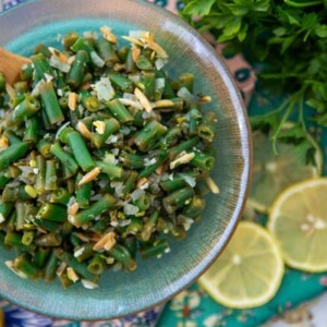 Lemon Tarragon Green Beans in a bowl with lemon slices in the background