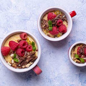 Millet Pudding in a cup topped with fresh raspberries and grated chocolate.