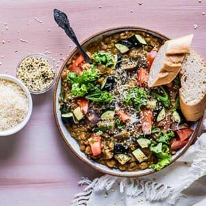 Vegetarian Lentil Stew in a bowl with crusty gluten free bread on the side.