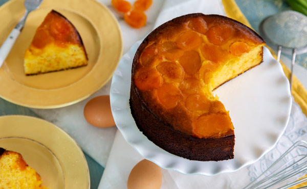 Sugar-Free & Grain-Free Almond Apricot Cake on a white serving platter with a slice cut out