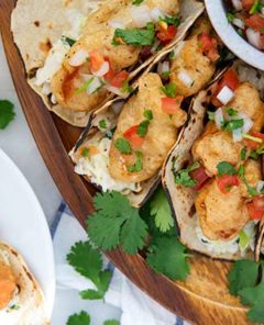 Baja Fish Tacos on a wooden serving platter with pico de gallo in a bowl