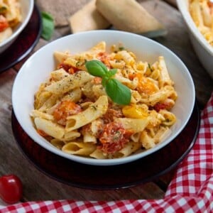 Baked Feta and Tomato Pasta in a bowl with a red and white checked napkin underneath