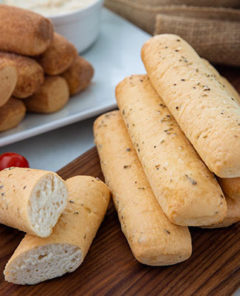 Savory breadsticks with garlic butter and sweet breadsticks in the background with cinnamon sugar