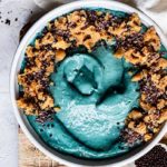 Closeup of Cookie Monster Smoothie Bowl, a bright blue smoothie with cookie dough on top