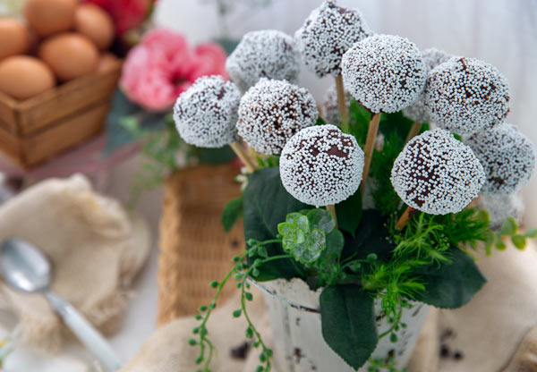 Easy Gluten-Free Cake Pops in a vase with fake leaves in between