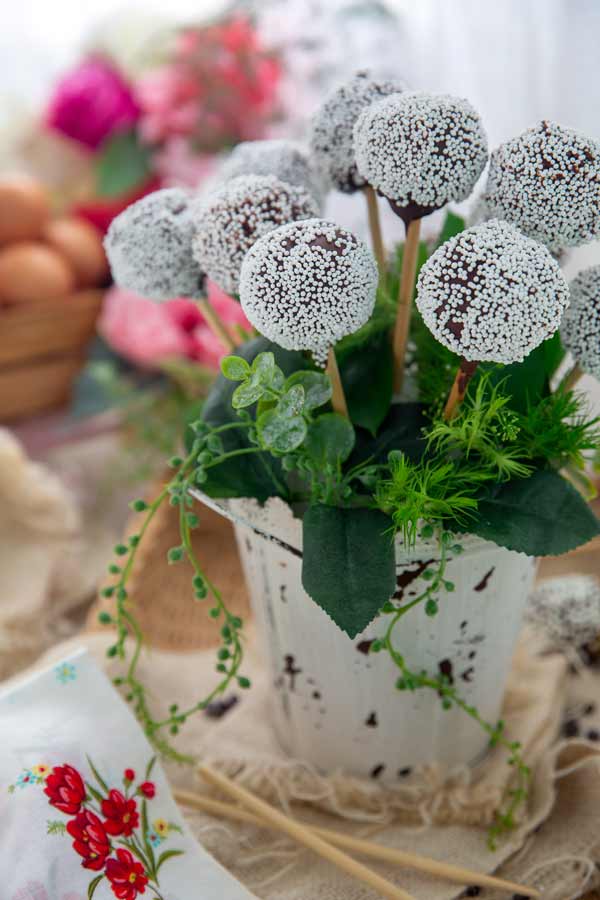 Gluten-Free Easy Cake Pops arranged with fake leaves in a vase