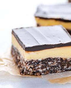 Close up of Gluten-Free Nanaimo Bars on parchment paper