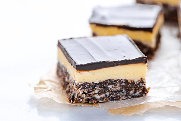 Close up of Gluten-Free Nanaimo Bars on parchment paper