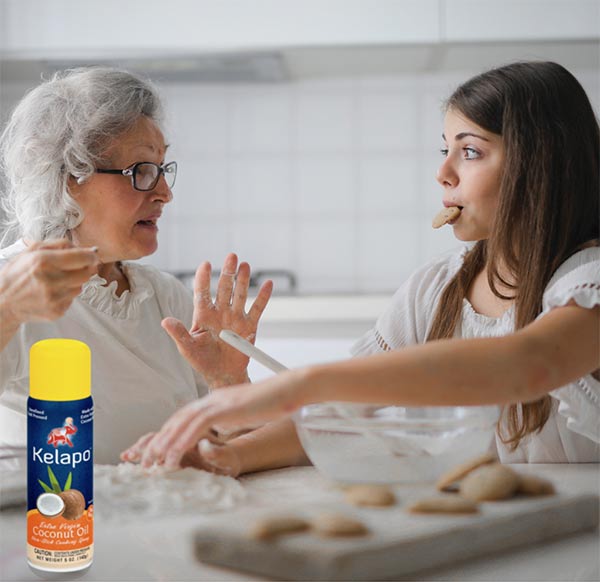 Kelapo Cooking Spray on a white kitchen counter with a grandma and granddaughter making cookies