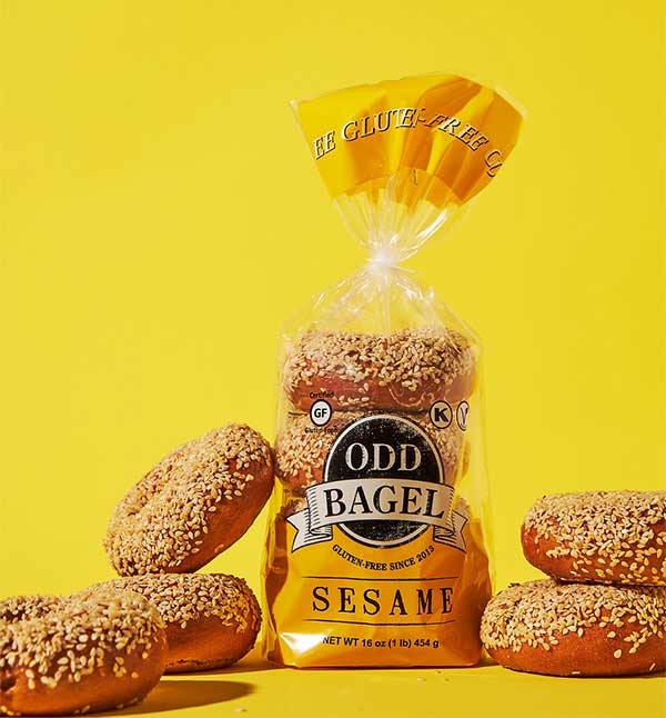 Odd Bagel Sesame Bagels in a package and outside the package on a yellow background