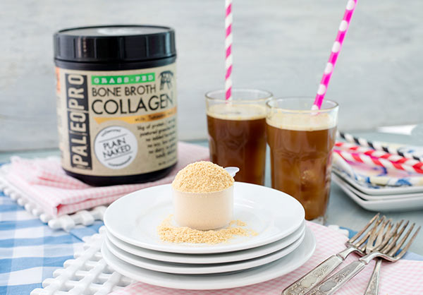 Paleo Pro Collagen Protein Powder in a scoop with glasses of protein shakes in the background