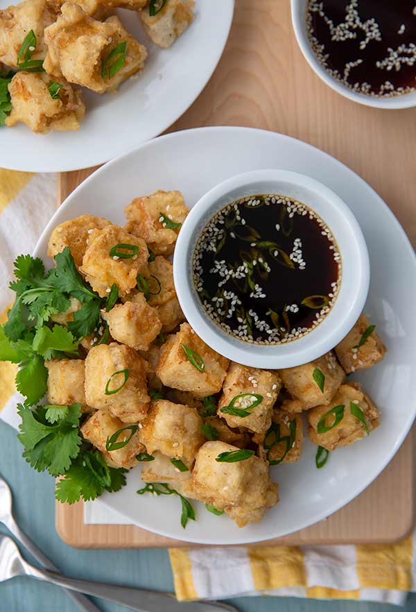 Tofu Tempura with Ponzu Sauce on a serving plate garnished with green onion