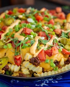 Fiesta Fries in a black skillet with blue cloth napkins underneath