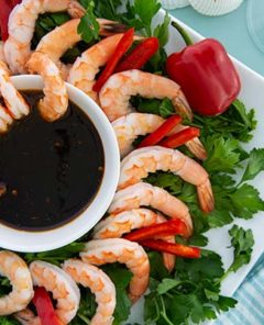 Shrimp Cocktail with Tamari Honey Dipping Sauce on a platter with greens underneath