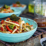 Spicy Beef and Vegetable Stir-Fry in a blue bowl with chop sticks on a bamboo placemat