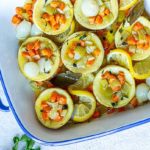 Artichokes Poached in Olive Oil in a white and royal blue baking dish