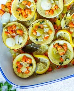 Artichokes Poached in Olive Oil in a white and royal blue baking dish