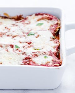 Gluten-Free Eggplant Parmesan in a white casserole dish on a white background