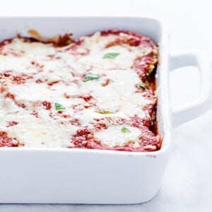 Gluten-Free Eggplant Parmesan in a white casserole dish on a white background