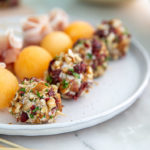 Goat Cheese Skewers with prosciutto and cantaloupe on a white plate