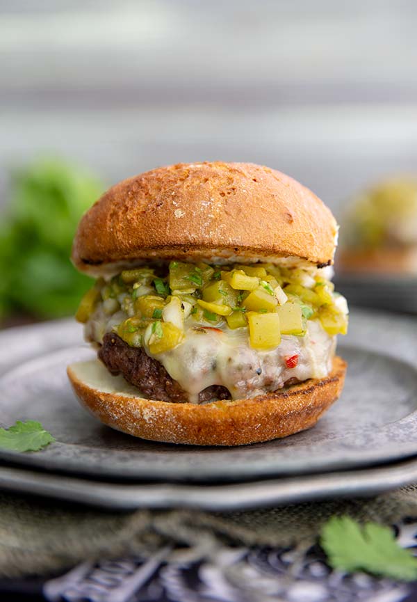 Closeup of a Green Chile Cheeseburger on a silver plate
