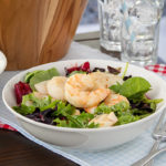 Grilled Seafood Salad in a white bowl with a light blue and white checkered towel and a red and white checkered towel underneath the bowl
