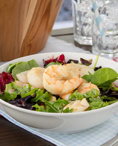 Grilled Seafood Salad in a white bowl with a light blue and white checkered towel and a red and white checkered towel underneath the bowl
