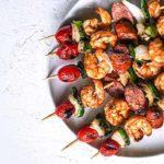 Shrimp and Andouille Sausage Skewers on a white plate