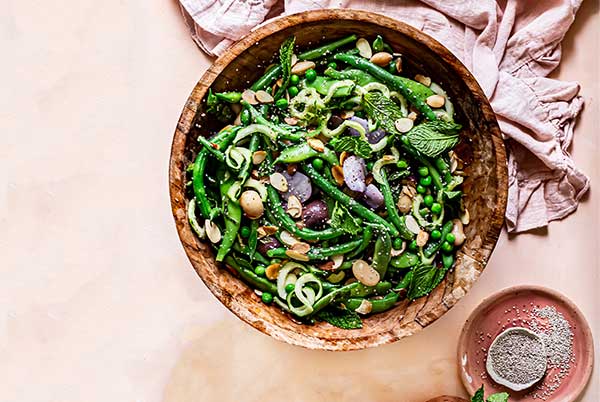 Summer Green Bean Potato Salad in a wooden bowl with a light pink cloth napkin underneath