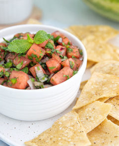 Watermelon Salsa in a white bowl with homemade tortilla chips on the side