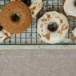 Applesauce Doughnuts on a wire cooling rack set over parchment paper on a burlap background