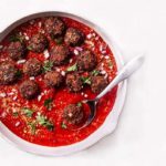 Vegetarian Italian Meatballs in red sauce in a white bowl on a white background