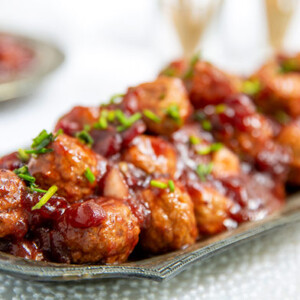 Cranberry Christmas Meatballs on a vintage serving tray on a white lace tablecloth