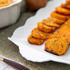 Garlic Parm Sweet Potato slices layered on a white decorative serving platter