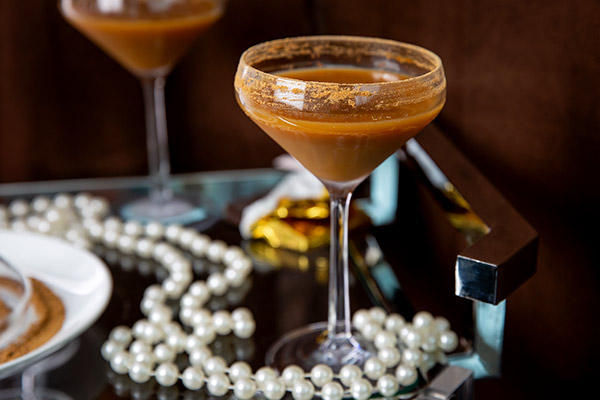Gluten-Free Alexander Cocktail in a glass on a bar tray with pearls around it