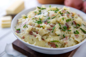 Mashed Red Potatoes in a white bowl topped with fresh chives