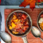 Sweet Potato & Leftover Turkey Soup in gray bowls with fall leaves in the background on an orange placemat