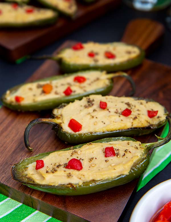Closeup of Hummus Jalapeno Poppers on a dark wooden cutting board