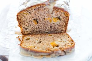 Closeup of Peach Bread with Cinnamon Almond Glaze on parchment paper