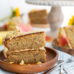 Slice of Sunbutter and Banana Cake with edible fall leaves on a brown wooden plate