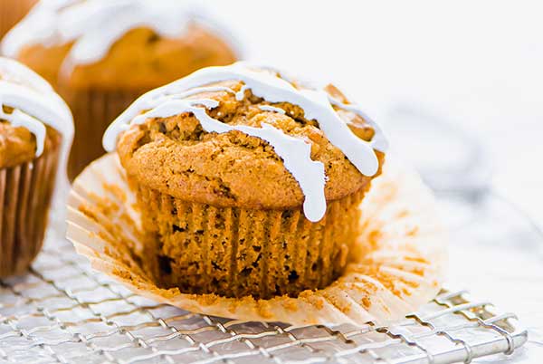 Sweet Potato Muffins drizzled with marshmallow icing on a wire rack