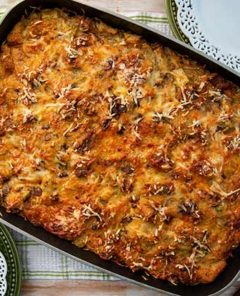 Overhead view of Sweet and Savory Bread Pudding in a casserole dish with white decorative plates on the side
