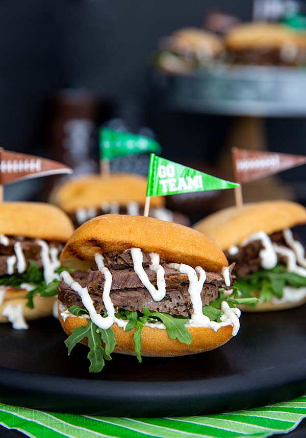 Tenderloin Sliders on a black serving plate with football decorations in the background